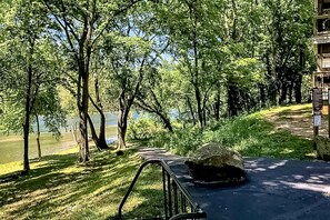 Un camino que lleva a un edificio con vistas a un lago y árboles.