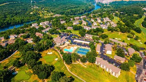 Ett flygbildsbild av ett bostadsområde med hus, en swimmingpool, tennisbanor och en golfbana.