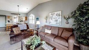 A spacious living area with a sofa, coffee table, and a large plant. - Inviting 2BR Condo - HOT TUB - Family Pool (Branson)