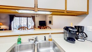 A kitchen with a double sink, a coffee maker, and a bottle of hand soap. - Rustic 2BR Condo - POOL & GOLF - Pet Friendly (Branson)