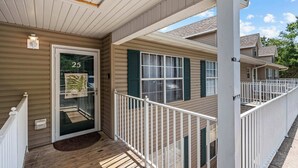 A residential building with a porch, a door with a number, and a window with shutters. - Rustic 2BR Condo - FARMHOUSE STYLE - Fall Creek (Branson)