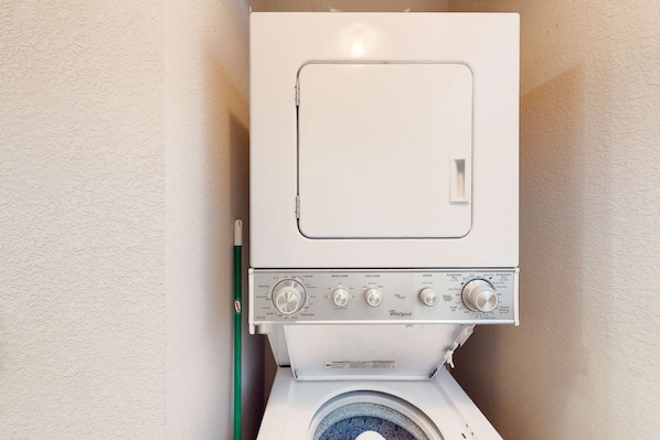 Eine weiße Whirlpool Waschmaschine ist in einem Badezimmer vor einem schlichten Wandbild zu sehen.