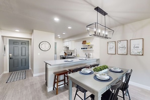 Una cocina moderna con una isla central, una mesa de comedor y sillas.