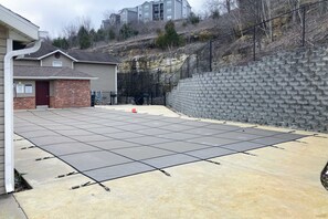 Ein gepflasterter Patio-Bereich mit einer Ziegelwand und einem Metallzaun.