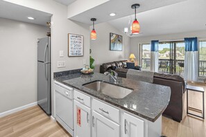 A modern kitchen with granite countertops, stainless steel appliances, and a built-in sink. - Serene 2BR Condo - POND VIEW - Pointe Royale (Branson)