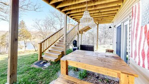 A wooden deck with a bench, a staircase, and a hanging light fixture. - Lakefront 4BR Cabin # POOL TABLE # Lake Views (Reeds Spring)