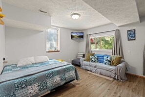 Ein Schlafzimmer mit zwei Betten, einem Fernseher, einem Fenster mit Vorhängen und einem an der Wand befestigten Schild.