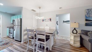 A modern kitchen with a dining area, a refrigerator, cabinets, and a table with chairs. - Bright 3BR Condo - MOUNTAIN VIEWS - Community Pool (Branson)