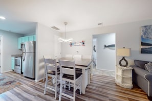 A modern kitchen with a dining area, a refrigerator, cabinets, and a table with chairs. - Bright 3BR Condo - MOUNTAIN VIEWS - Community Pool (Branson)
