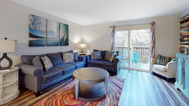 A living room with a sofa set, a coffee table, a lamp, and a painting on the wall. - Bright 3BR Condo - MOUNTAIN VIEWS - Community Pool (Branson)