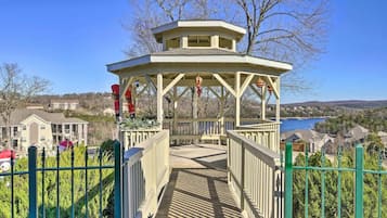 A gazebo with a view of a lake and houses in the background.