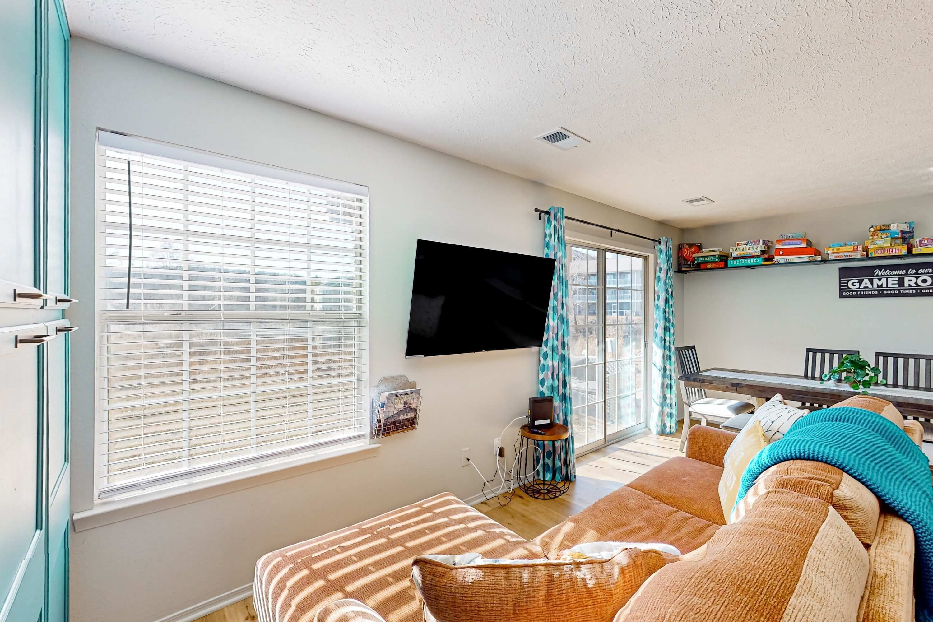 A living room with a sofa, a flat-screen TV, and a bookshelf.