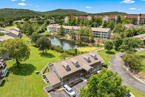 Ein Wohngebiet mit einem See, Häusern und einem Gebäude mit Garage und überdachtem Parkplatz.