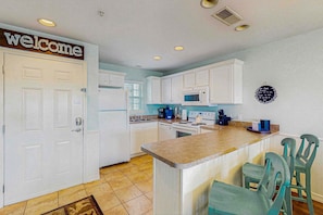 A kitchen with white cabinets, a microwave, a coffee maker, and a welcome sign. - Pet-Friendly 2BR # Community POOL # Valley Views (Kimberling City)