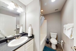 A bathroom with a sink, mirror, and toilet. - Bright 3BR Condo - MOUNTAIN VIEW - Near Pool (Branson)