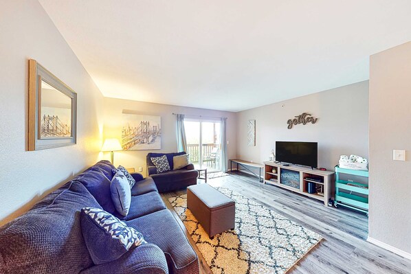 A living room with a sofa, a television, a coffee table, and a patterned rug. - Bright 3BR Condo - MOUNTAIN VIEW - Near Pool (Branson)