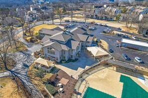 A residential area with a large house, a parking lot, and a playground. - GOLF VIEWS - 2BR Condo - Creek Views at Turnberry (Branson)