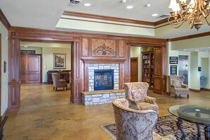A lobby with a stone fireplace, patterned armchairs, a glass coffee table, and a chandelier. - Ground-Floor 2BR # POOL & GOLF # Pet Friendly (Branson)