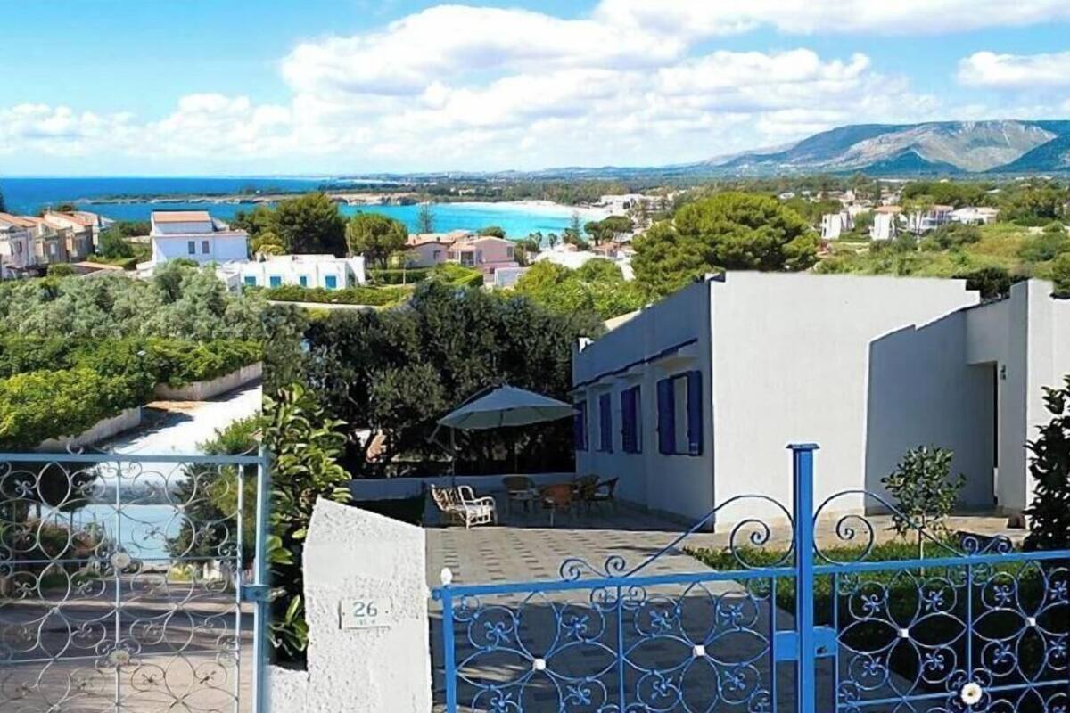 Eine Wohngegend an der Küste mit Meerblick, einem Pool und einem Gebäude mit blauem Tor.