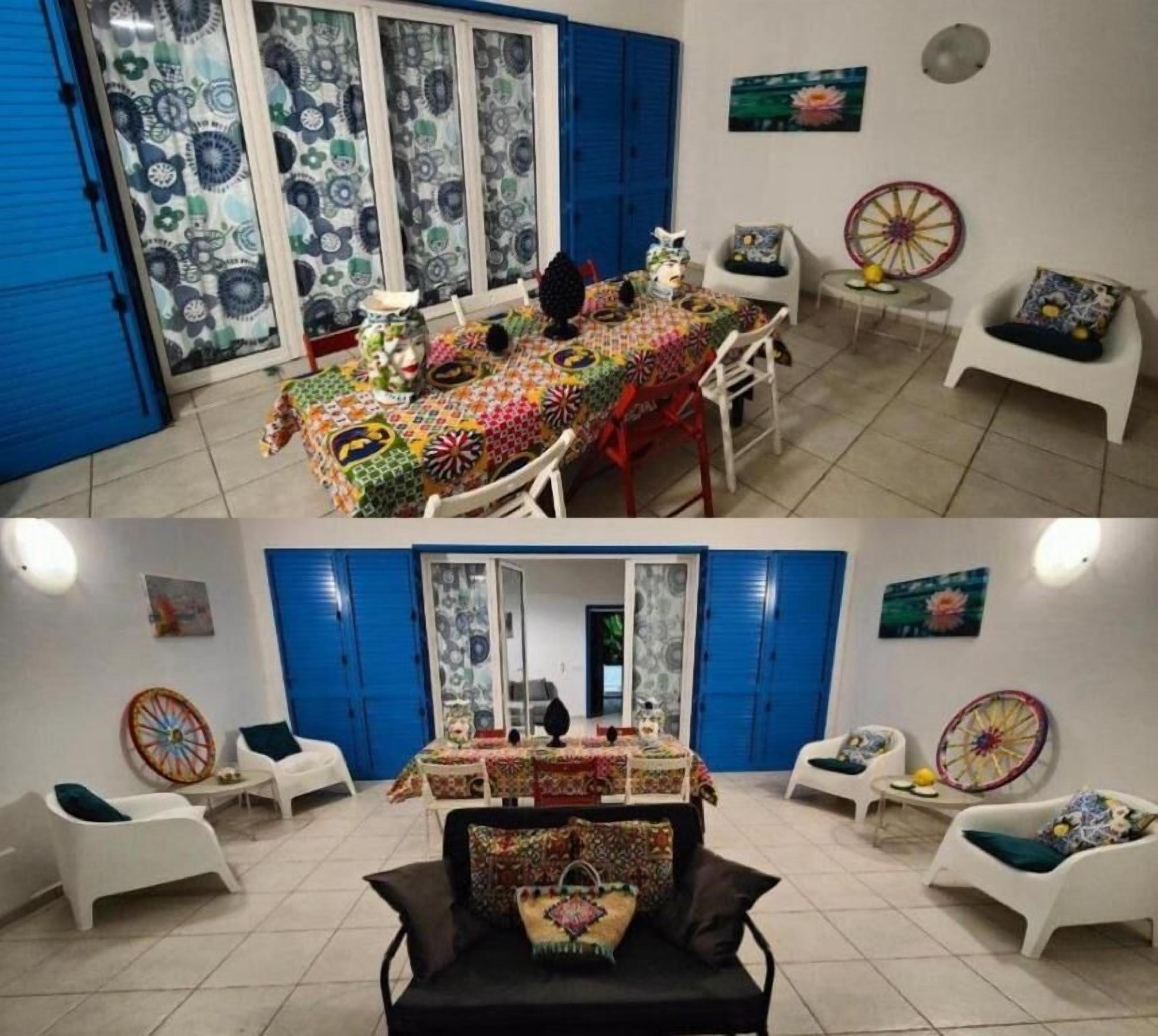 Un coin repas avec une table dressée pour quatre personnes, entourée de chaises blanches, et un espace salon séparé avec deux chaises blanches et une petite table.