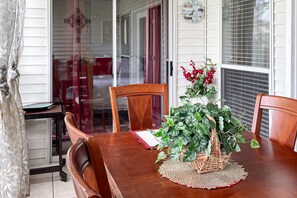 A dining table with chairs, a wicker basket with a plant, and a clock on the wall. - Golf View 2BR Condo - JACUZZI TUB - Branson (Branson)