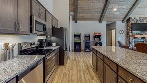 Eine Küche mit Granit Arbeitsplatten, Edelstahlgeräten und Holzschränken.