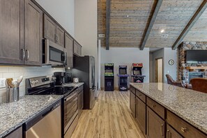 Eine Küche mit Granit Arbeitsplatten, Edelstahlgeräten und Holzschränken.