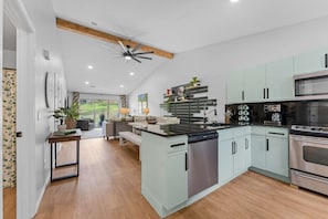 A modern kitchen with a central island, stainless steel appliances, and light-colored cabinetry. - Peaceful 2BR Condo - DUCK POND VIEWS - Branson (Branson)