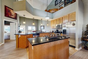 A spacious kitchen with wooden cabinets, a large island, and modern appliances. - LAKE VIEW 3BR Condo - Pool & Entertainment Ready (Branson)