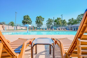 Un espace piscine avec des chaises longues et un ciel d’un bleu éclatant.