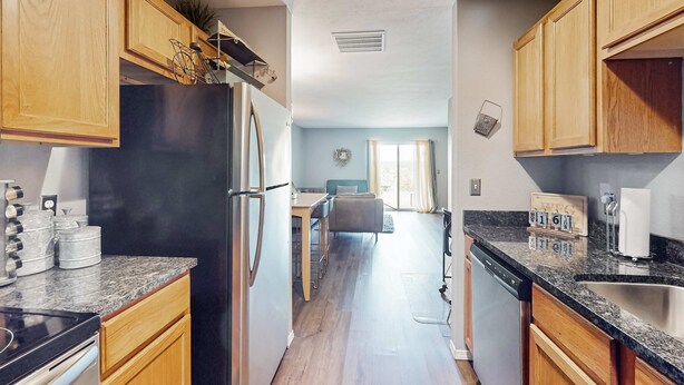 A kitchen with wooden cabinets, a refrigerator, a stove, and a dishwasher. - Warm 3BR Condo - MOUNTAIN VIEWS - COMMUNITY POOL (Branson)