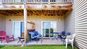 A covered patio with outdoor furniture, a wooden deck, and a grassy lawn. - Warm 3BR Condo - MOUNTAIN VIEWS - COMMUNITY POOL (Branson)