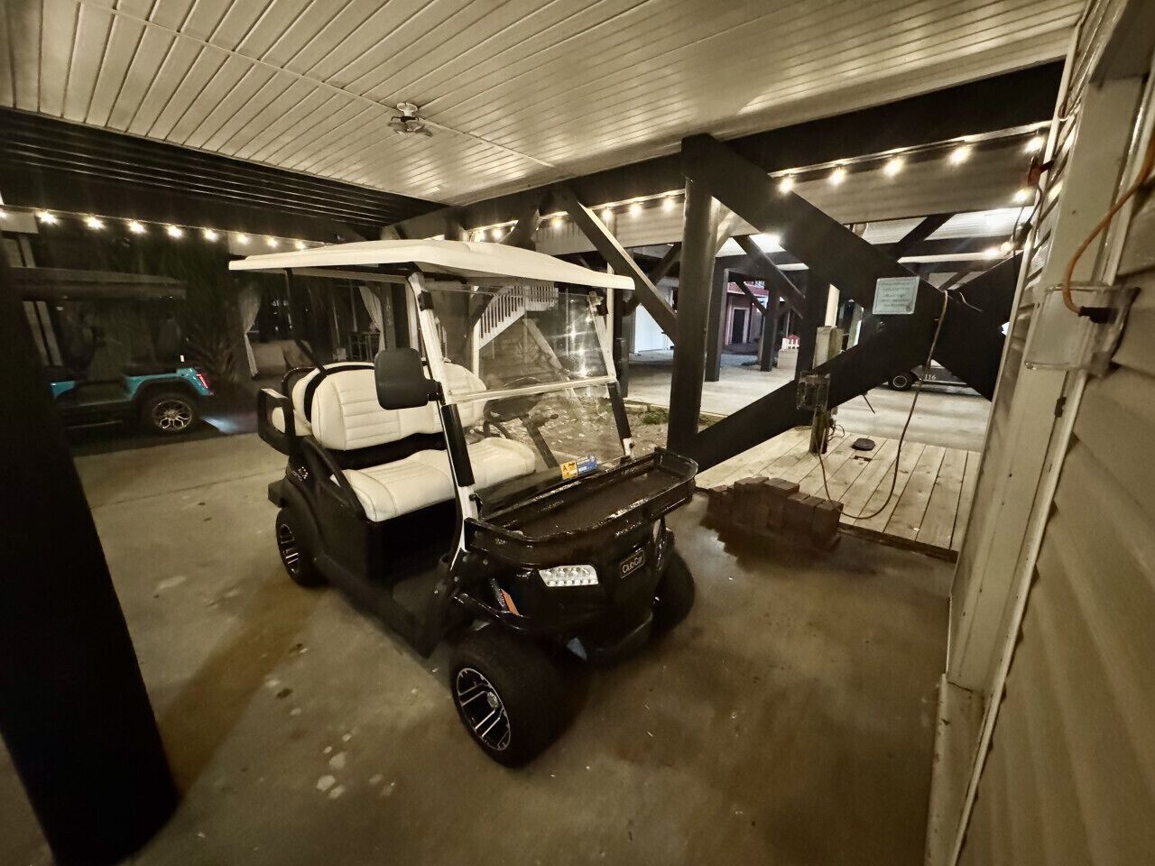 Un'area di parcheggio coperta con un carrello da golf e un piccolo veicolo.