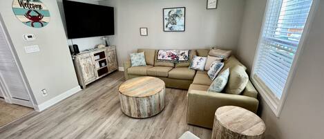 A living room with a sofa, coffee table, and a TV.