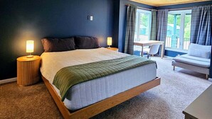 A bedroom with a bed, bedside lamps, a desk, and a chair. - Hessel Bay Main Cabin : Idyllic Les Cheneaux Islands waterfront cabin sleeps 8 (Hessel)