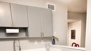 Eine moderne Küche mit grauen Schränken, Edelstahlgeräten und Holzboden.