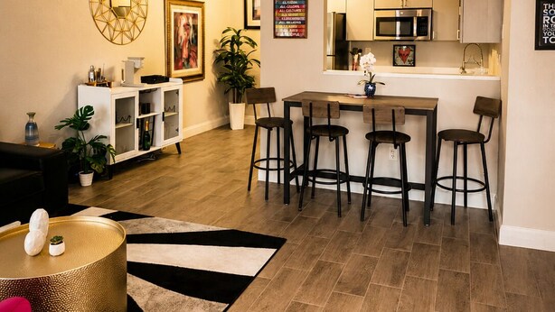 Ein modernes Wohnzimmer mit Essbereich, Küche und Deckenventilator.