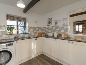 Una cocina moderna con lavadora, un lavamanos y una ventana con vistas.