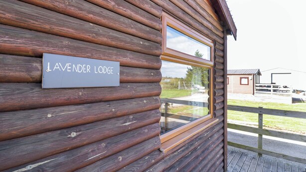 A wooden cabin with a sign reading 'JAVENDER LODGE.' - Lavender Lodge (Evesham)