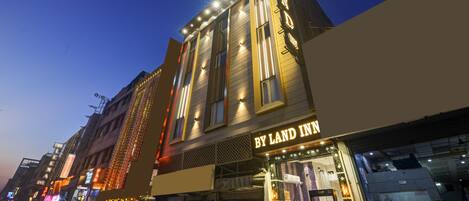 A building with a sign reading 'BY LAND INN' and a visible storefront.