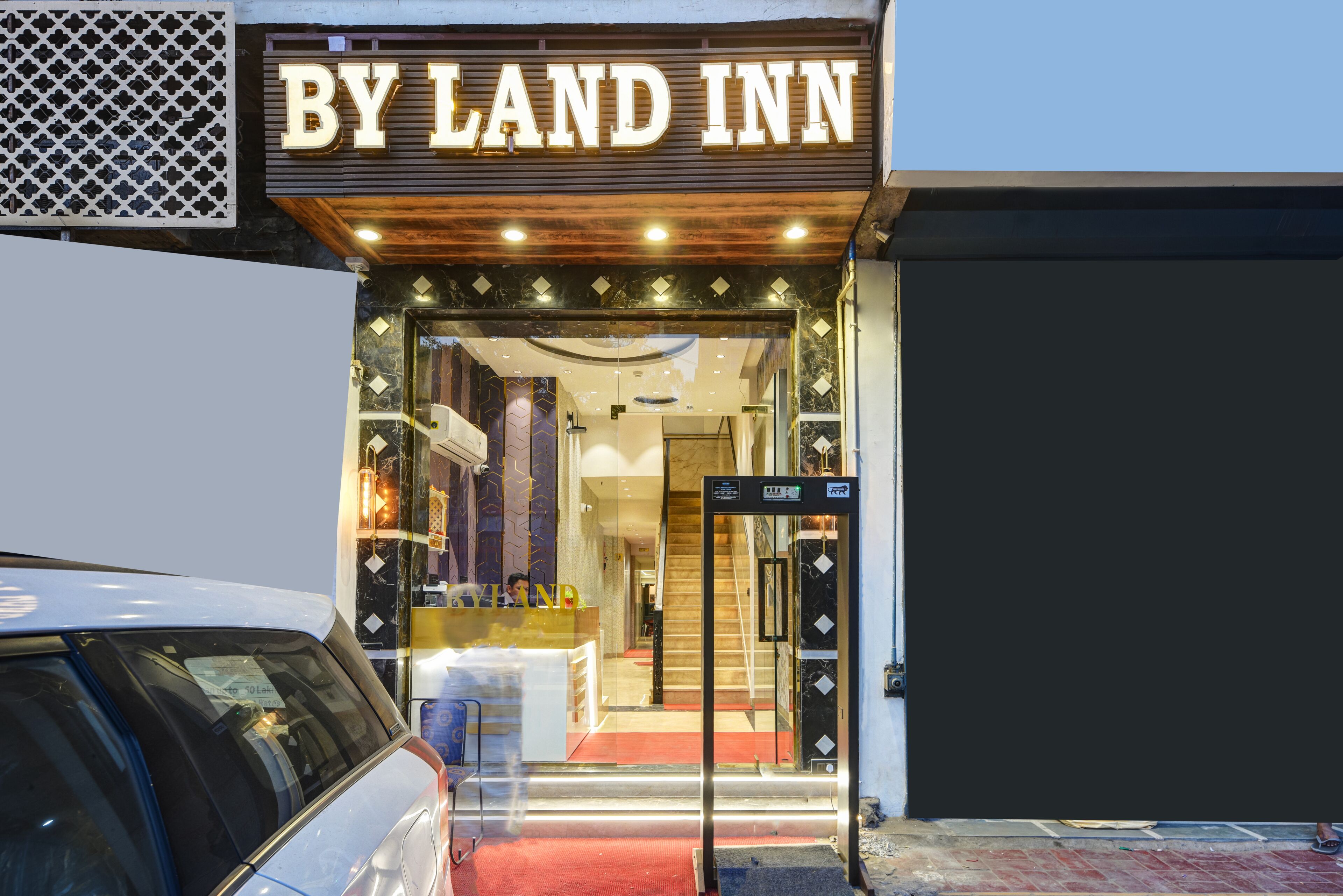 La entrada a un hotel con un letrero que dice 'BY LAND INN'.