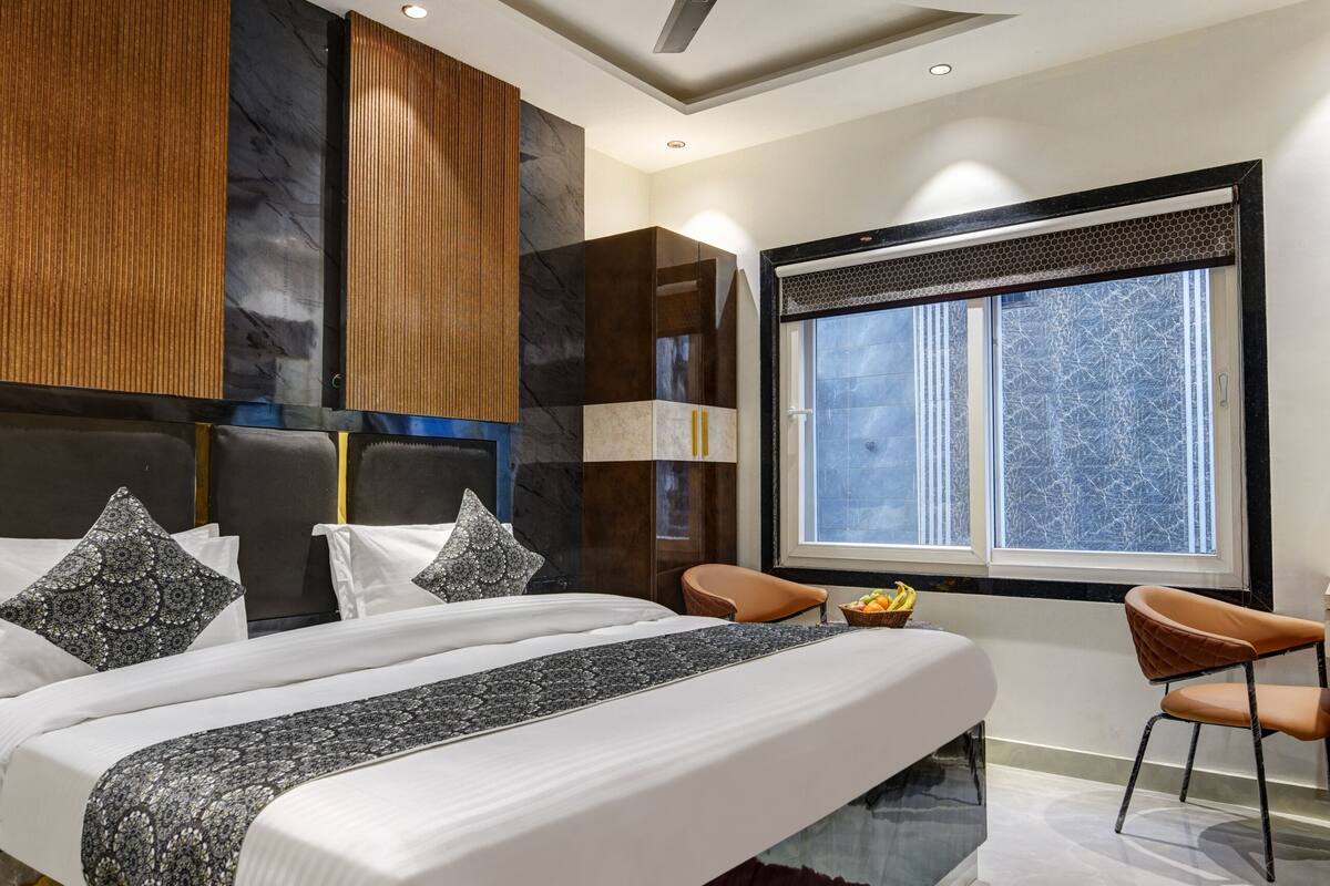 A modern bedroom with a bed, a ceiling fan, a window, and a red rug.