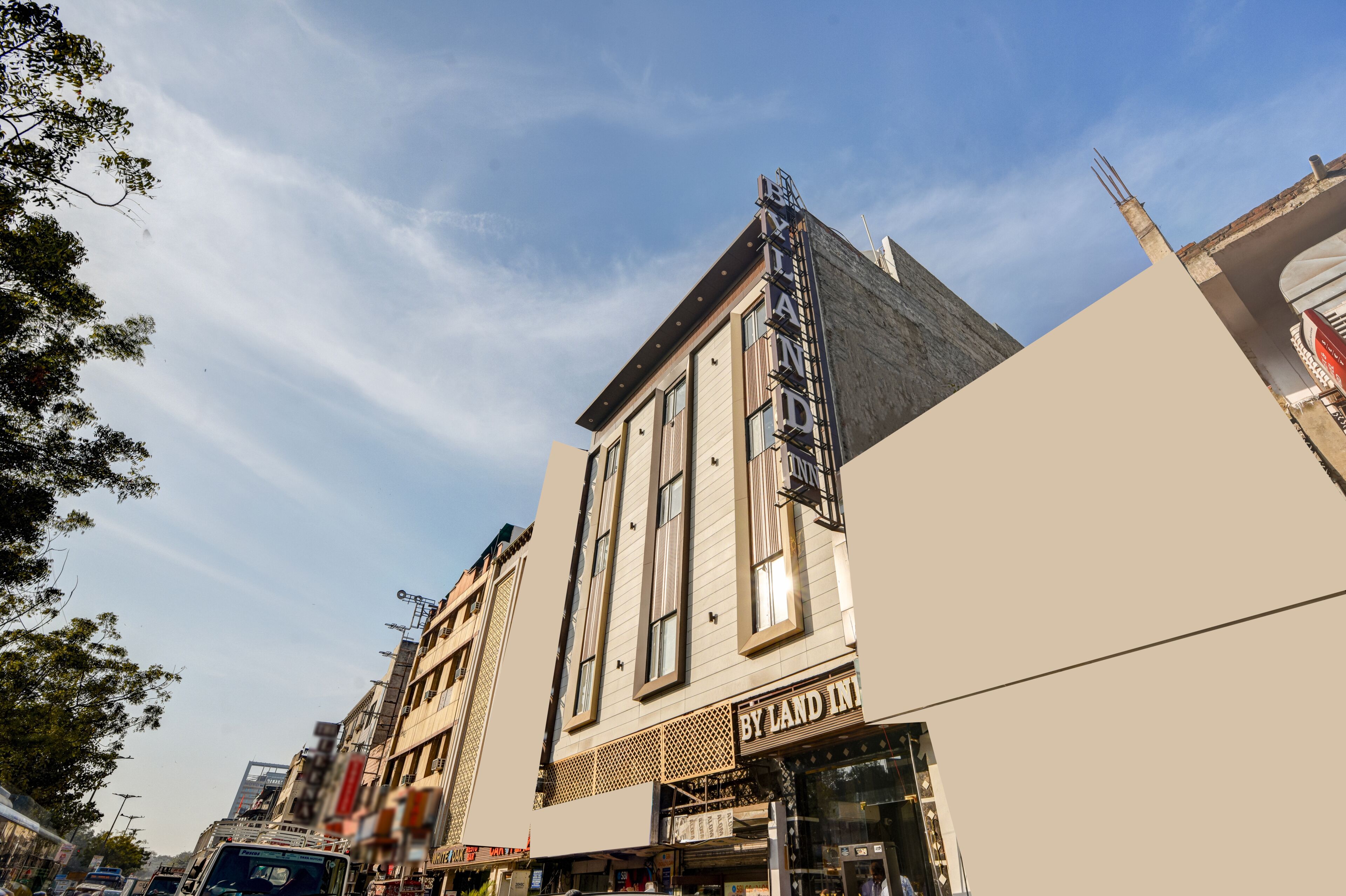 A multi-story building with a prominent sign reading 'BY LAND INN' on the ground floor.