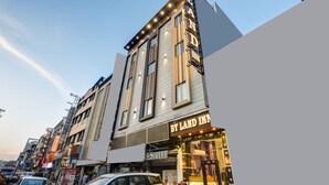 Un hotel con un letrero llamativo que dice 'BY LAND INN' y un diseño arquitectónico moderno.