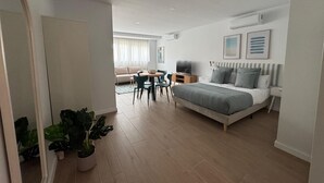 A modern bedroom with a large bed, bedside tables, a desk, and a chair. - Apartamentos Marcela by gaiarooms (León)