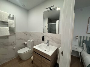 Studio | Badkamer | Een douche, een haardroger, handdoeken, zeep