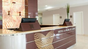 A hotel reception desk with a modern design, a large mirror, and a sign indicating the hotel name. - Hotel La Palma de Llanes by gaiarooms (Llanes)