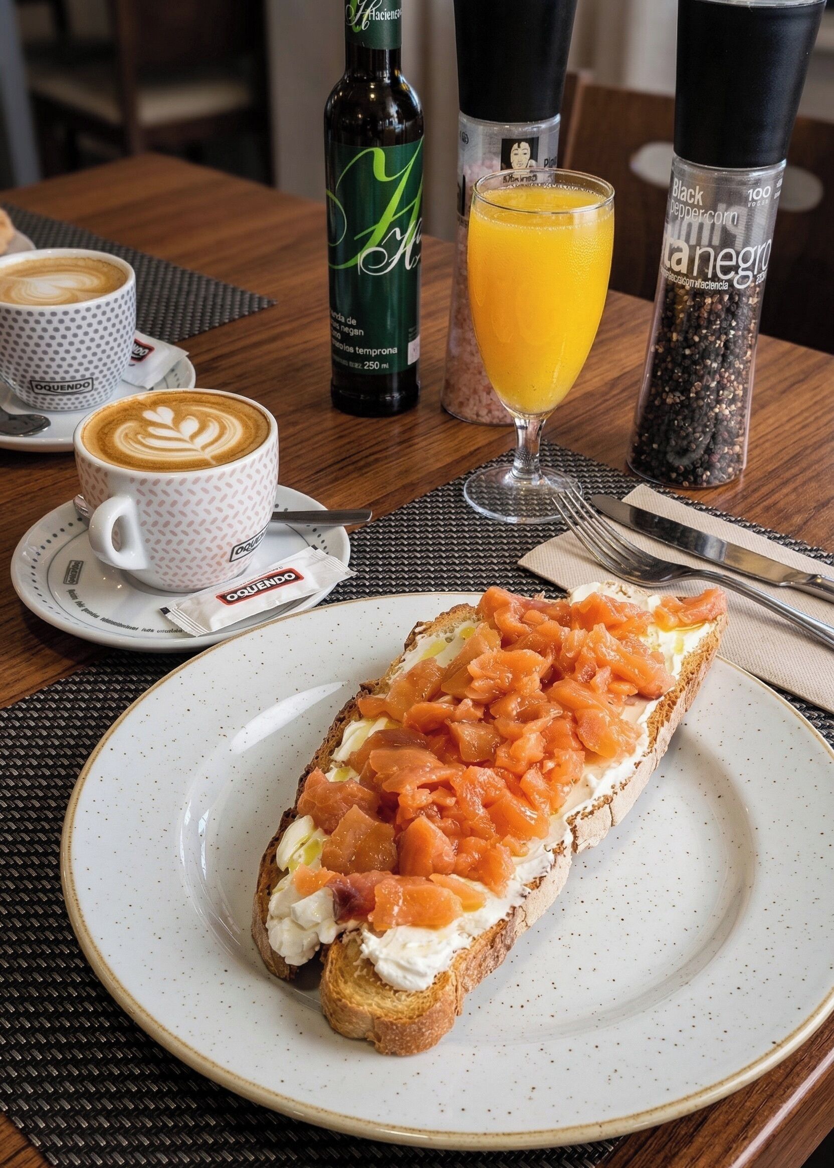 A breakfast setting with a sandwich, coffee, and juice on a table.