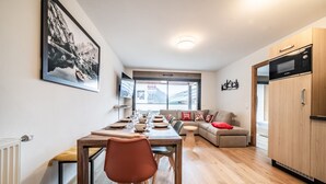 A modern kitchen with a microwave, wooden cabinets, and a dining area with a table set for four.