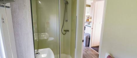 A bathroom with a shower, toilet, and sink.